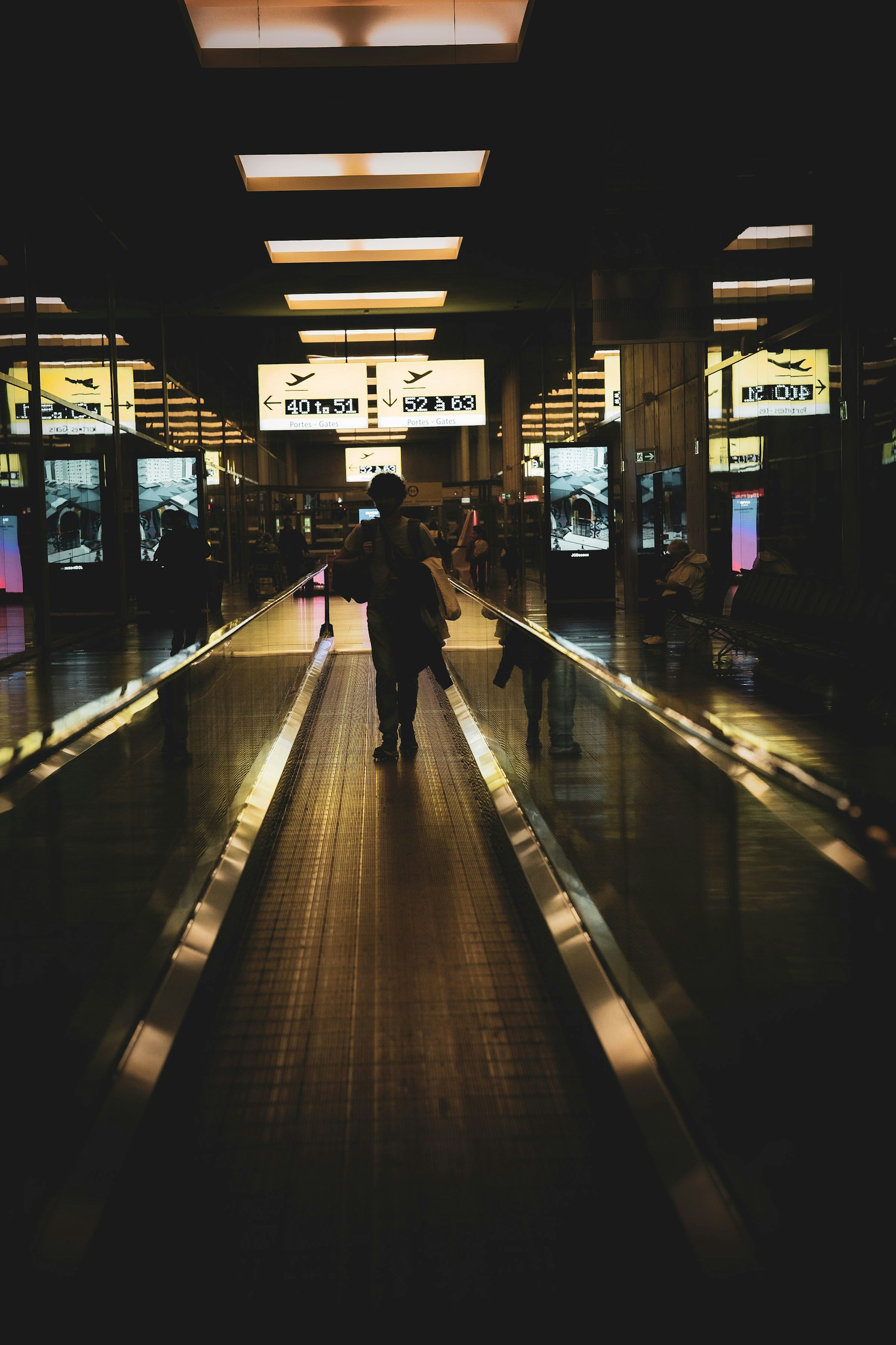 Traveler moving through a warmly lit airport terminal with quiet service atmosphere